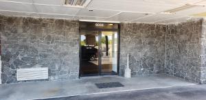 科珀斯克里斯蒂Executive Inn的一座带石墙的建筑的前门