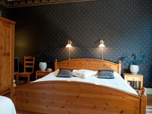 哥德堡艾卡兰达住宿加早餐旅馆的一间卧室配有一张带蓝色波尔卡点壁纸的木床。