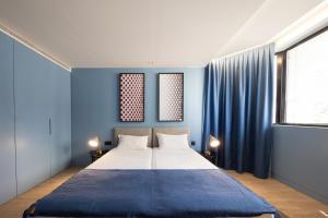 波尔图BessaApartments的一间卧室配有一张带蓝色墙壁的大床