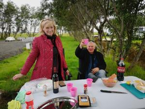 海拉Iceland Igloo Village的站在桌子旁的女人,拿着一瓶葡萄酒