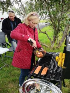 海拉Iceland Igloo Village的女人在烧烤架上做饭