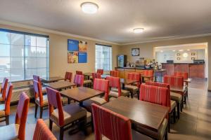 埃尔森特罗Comfort Inn & Suites El Centro I-8的餐厅设有木桌和红色椅子