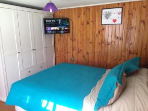 圣地亚哥Casa en Santiago equipada的一间卧室配有一张带蓝色毯子的床