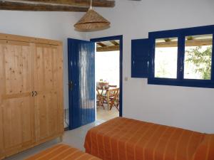 穆里略德加列戈阿玛丽格尔露营地的卧室设有蓝色门、一张床和一张桌子