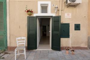 莫诺波利Dimora del Murattiano的通往带绿门和椅子的大楼的门道