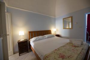 莫诺波利Dimora del Murattiano的一间卧室配有一张床、一盏灯和一面镜子