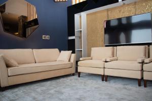 阿可贺巴Durrat Manzli ApartHotel的客厅配有2张沙发和1台平面电视