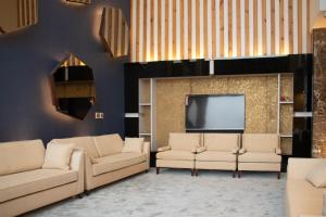 阿可贺巴Durrat Manzli ApartHotel的客厅配有两张沙发和一台电视机