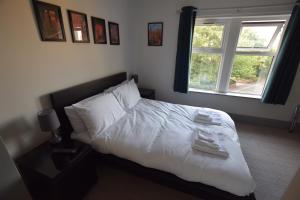 谢菲尔德The Crow Inn的一间卧室配有一张带白色床单的床和一扇窗户。