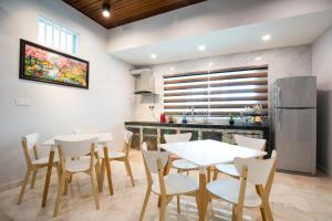怡保Canning 33的厨房以及带白色桌椅的用餐室。