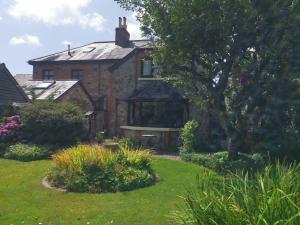 艾维布里奇Thornham Cottage的一座古老的砖房,前面有一个花园