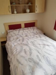 西卢港Caravan Willerby Gold Star的卧室配有带白色棉被的床