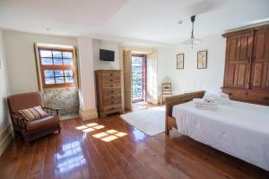 拜昂Casa do Monte - Douro的一间卧室配有一张大床和一把椅子