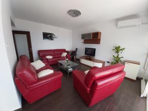 卡斯塔夫Apartment Alina, Kastav的客厅配有两张红色的沙发和一张桌子
