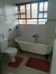 阿曼济姆托蒂Pam's Beach Flat的浴室配有白色浴缸和卫生间。
