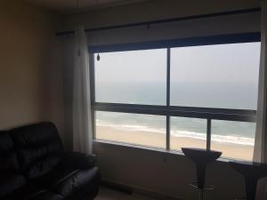 阿曼济姆托蒂Pam's Beach Flat的客厅设有可欣赏海滩美景的窗户。