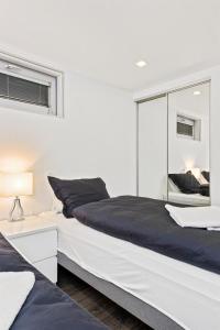 沃斯山顶公寓的白色卧室设有一张大床和镜子