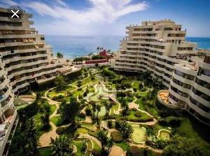 马拉加Benalbeach JR Suite的享有拥有建筑和大海的度假胜地的景色