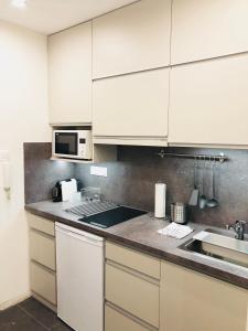 布达佩斯Heroes’ Residence II的厨房配有白色橱柜和水槽
