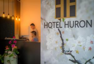 莫尔Hotel Huron的两幅酒店客房的照片,带白色鲜花