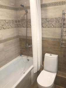 乌法Студия люкс на Гафури的浴室配有白色卫生间和浴缸。