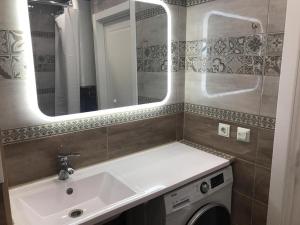 乌法Студия люкс на Гафури的一间带水槽和镜子的浴室以及一台洗衣机