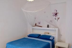 圣伊西多罗Colori Salentini Appartamento Sabbia的卧室配有一张带蓝色床单和蝴蝶的床铺。