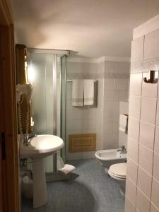 格雷索圣尚格兰白塔酒店的浴室设有2个卫生间、水槽和淋浴。