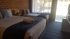 科夫斯港皇家棕榈汽车旅馆的酒店客房,设有两张床和一张沙发