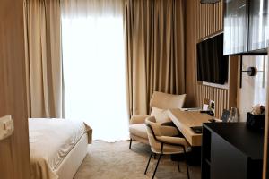 萨格勒布Pod Zidom Rooms的酒店客房配有一张床、一张桌子和一把椅子。
