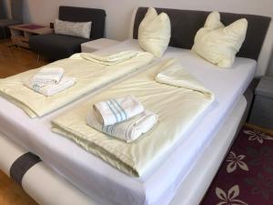 格拉茨Komfortables Appartement/Garconniere in Graz für Urlaub und Geschäftsreisen的两张床,上面配有毛巾和枕头
