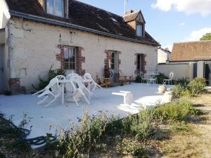 MonthodonChambre d'hôte Monthodon的房屋前带白色椅子的庭院
