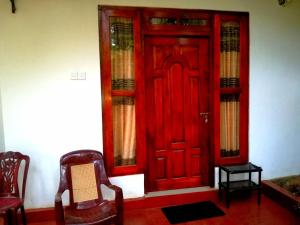 埃拉Ella Sunrise的一个带两把椅子的房间的红色门