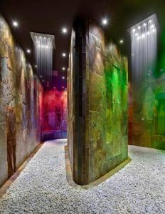 蒙特格罗托泰梅Terme di Relilax Boutique Hotel & Spa的一间拥有色彩缤纷的灯光的石墙客房