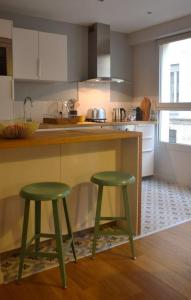 波尔多Burdigala Homes - Appart de Lalande的厨房配有2张位于柜台旁的绿色凳子
