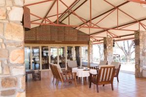 GrootfonteinDornhuegel Guest Farm的一间带桌椅和石墙的用餐室