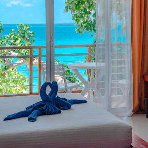迪古拉阿提里马尔代夫海滩酒店的窗前的一张带蓝色丝带的床