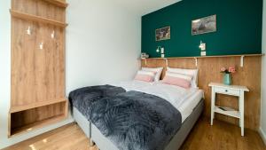卡尔帕奇Apartamenty Sun & Snow Triventi Mountain Residence的一间卧室设有一张床和绿色的墙壁