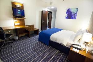 麦纳麦巴林假日酒店的酒店客房配有一张床、一张书桌和一台电脑