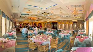 尼玛纳尼梅拉堡-宫殿酒店的宴会厅配有粉红色的桌椅