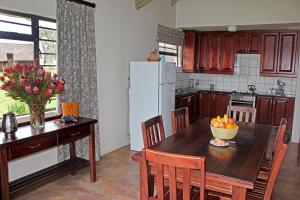 伯格维尔Sungubala Eco Camp的厨房配有木桌和冰箱。