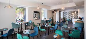 尼斯阿克罗波利斯驿站酒店的餐厅设有蓝色和绿色的桌椅