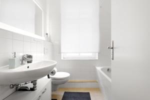 柏林中央米特公寓 的白色的浴室设有水槽和卫生间。