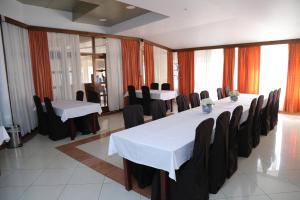 Ivanec奥里昂酒店的一间会议室,配有白色的桌子和黑色的椅子