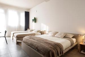 帕多瓦Casa a Colori Padova的白色卧室配有两张床和一张沙发