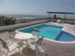 圣路易斯卡尔豪普拉亚酒店的海滩旁的游泳池配有桌椅