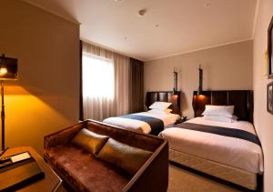 高松高松皇家花园酒店的酒店客房,设有两张床和一张沙发