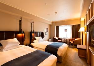 高松高松皇家花园酒店的酒店客房配有两张床和一张书桌