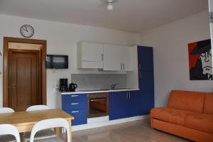 加尔达湖滨Villa Dina的厨房以及带蓝色橱柜和桌子的客厅。