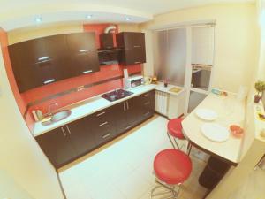戈梅利Apartment on Lenin Avenue的一间带桌子和红色椅子的小厨房